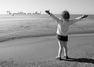 A woman standing on the beach with her arms outstretched.